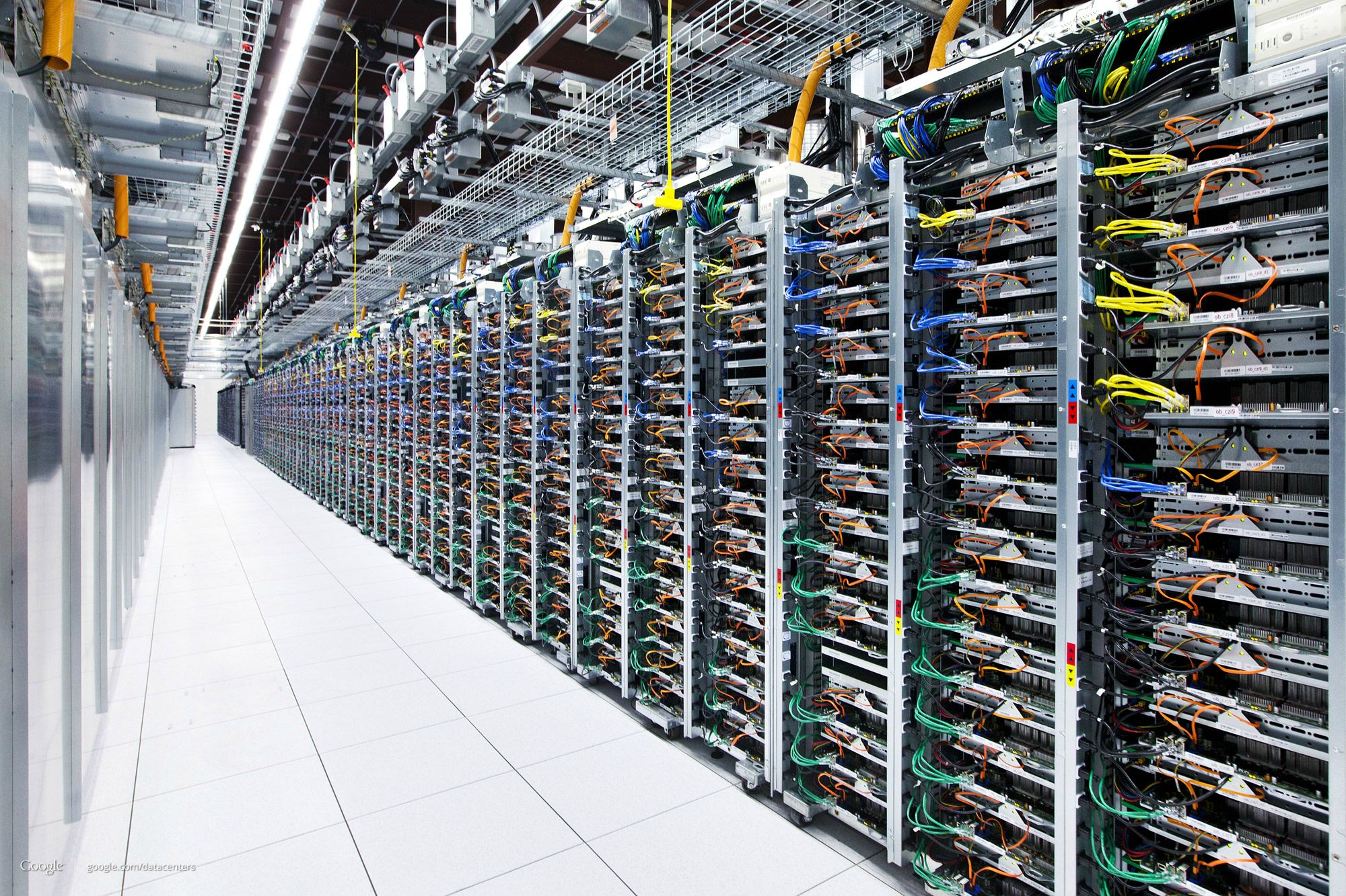 Inside of a data center showing dozens of racks of servers